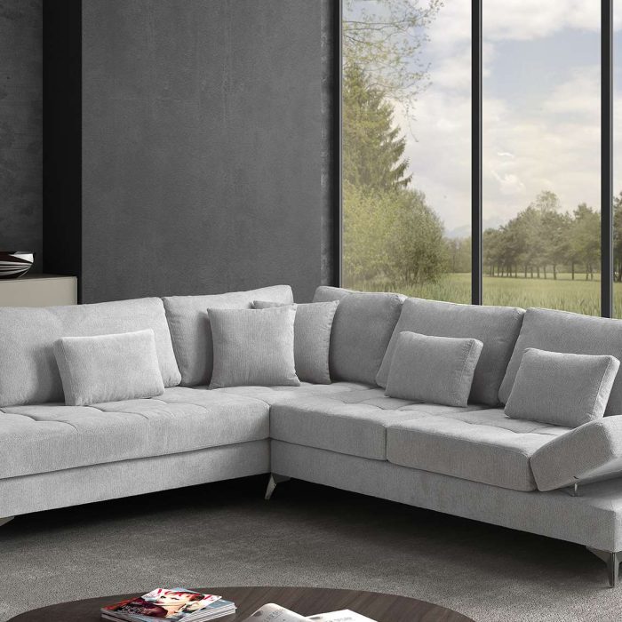 Divano angolare grigio Chantal da 294x234 cm con piedini in metallo e cuscini d'arredo.