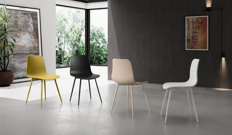 Quattro sedie moderne modello Cover disposte in ambiente giorno nelle varianti giallo senape, nero opaco, beige e bianco